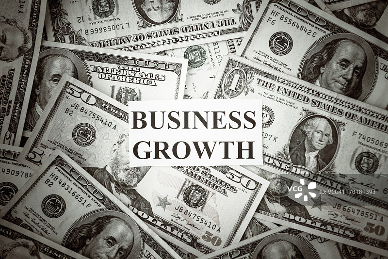 带有业务增长文字的一堆美元图片素材