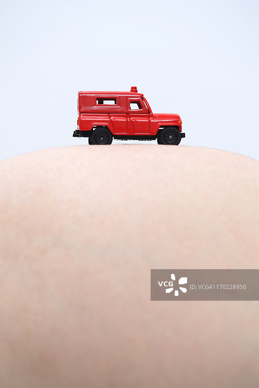 孕妇的腹部特写，背景为吉普车图片素材