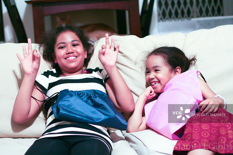 两个女孩坐在沙发上玩耍图片素材