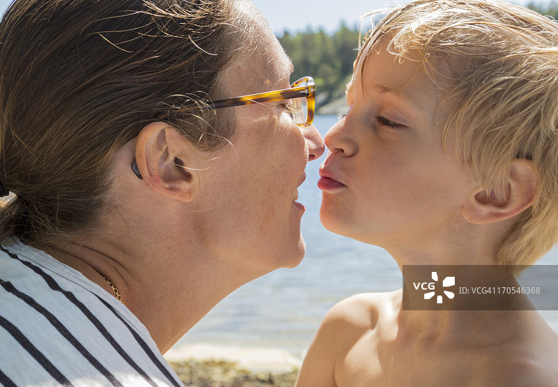 母子在夏季背景下亲吻图片素材