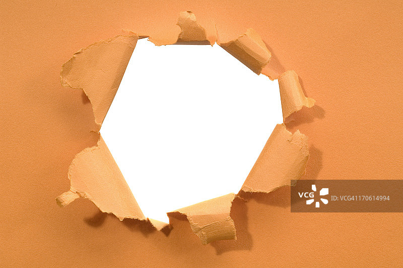 白色背景上撕裂的纸洞图片素材