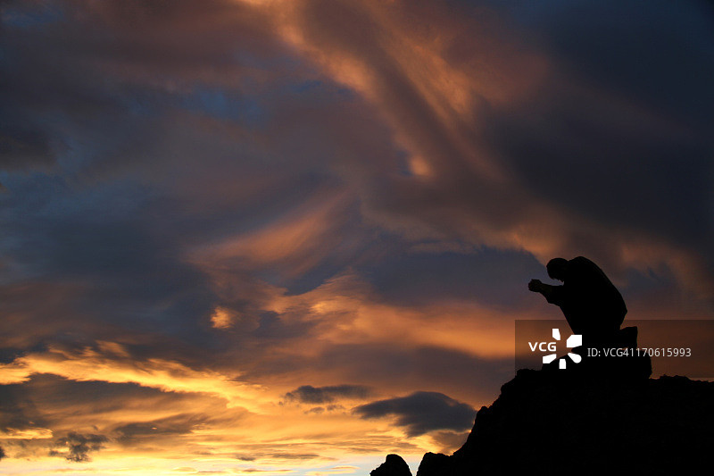 在山上跪着祈祷的男人轮廓图片素材