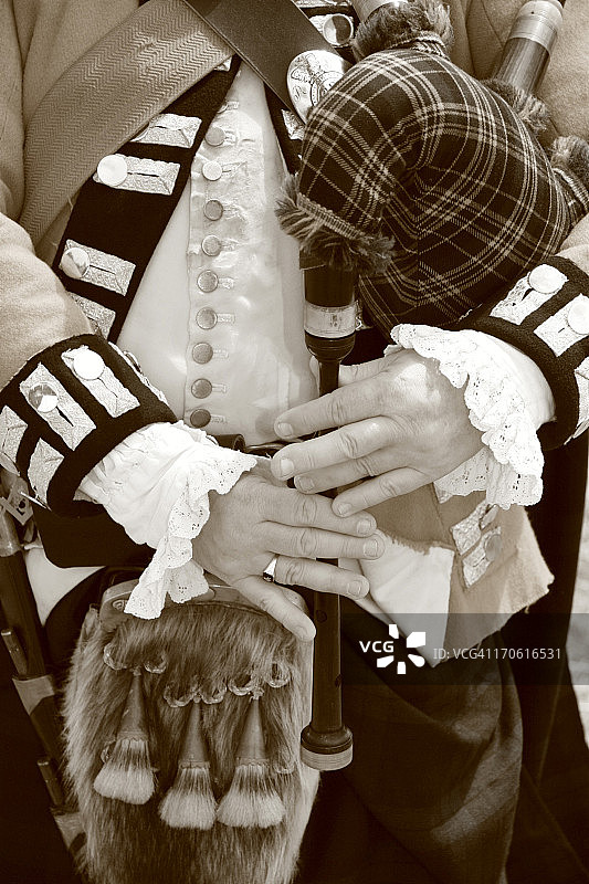 风笛手的手部特写-棕褐色调黑白照片图片素材