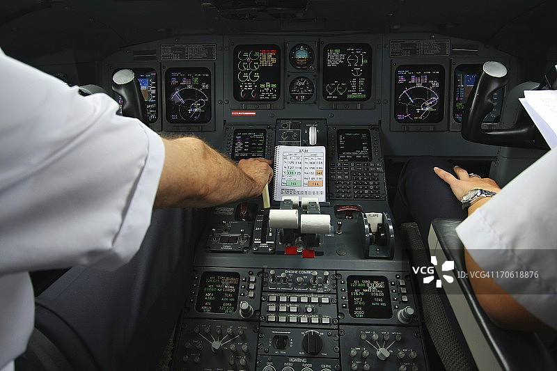 现代化商用飞机驾驶舱：飞行员工作中图片素材