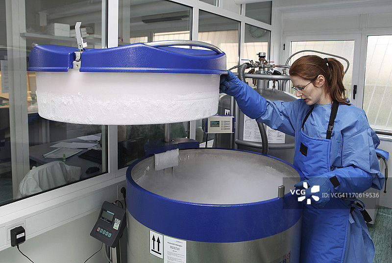 装有液氮的容器…穿着防护服的医生在工作图片素材