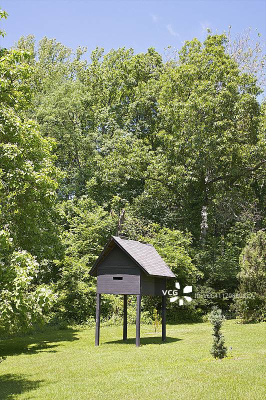 草地上高脚的黑色鸟舍图片素材
