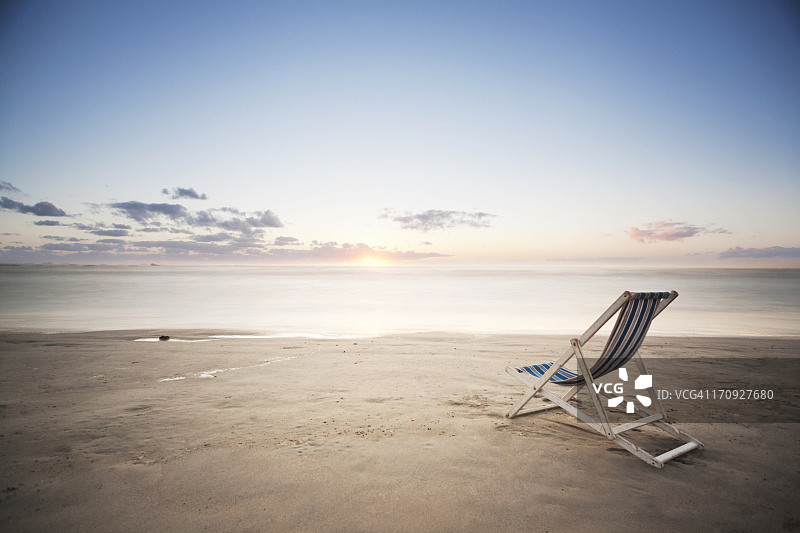 日落时分沙滩上的躺椅图片素材