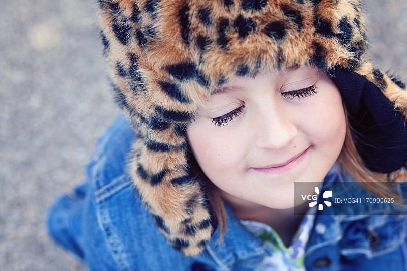 戴着动物帽子并闭着眼睛的女孩图片素材
