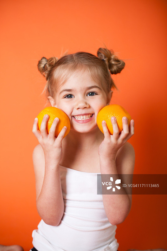 橙色背景上的可爱小女孩图片素材