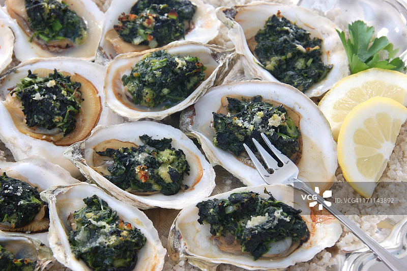美味的洛克菲勒牡蛎，配有叉子和柠檬图片素材
