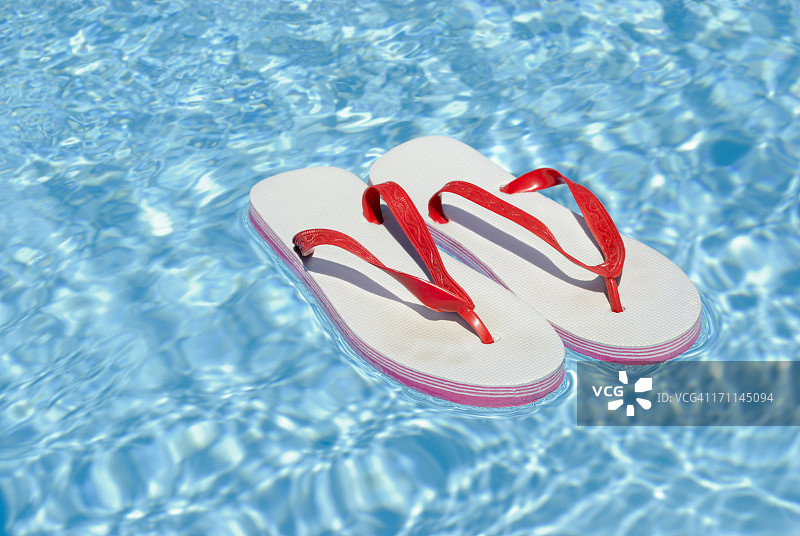 漂浮在游泳池上的凉鞋图片素材