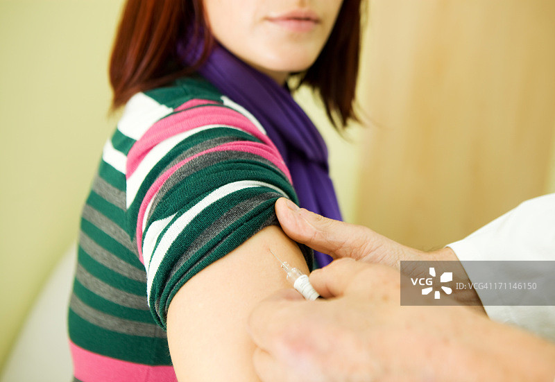年轻女性的流感疫苗接种，护士工作中图片素材