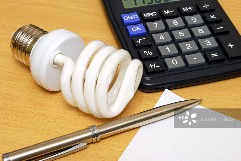 紧凑型荧光灯泡、计算器和笔图片素材