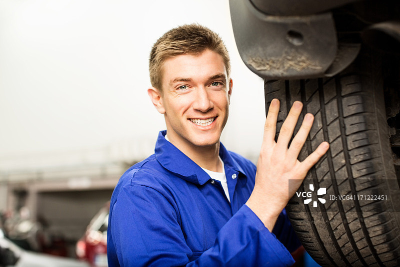 更换轮胎的年轻技工图片素材