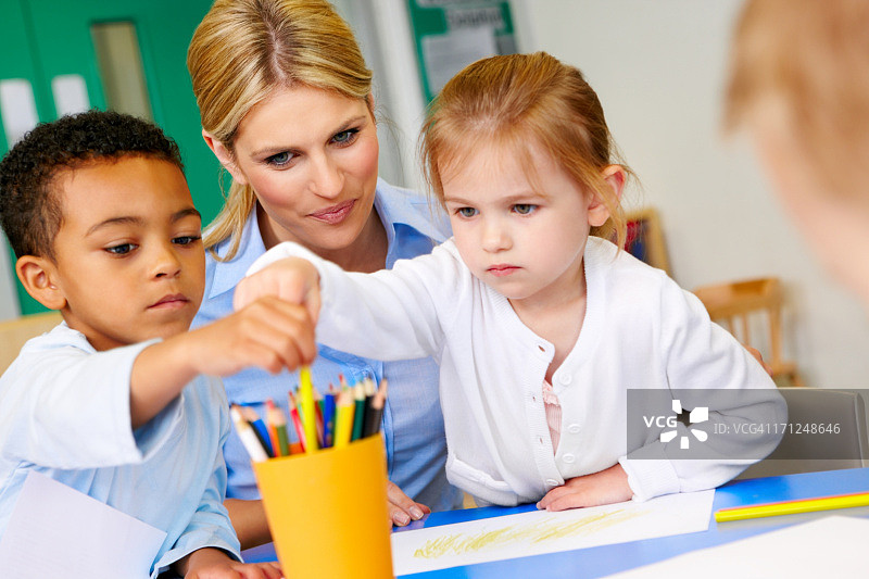 在游戏室里和老师在一起的学龄前儿童图片素材