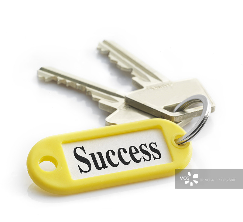 标有成功的黄色钥匙链上的钥匙特写图片素材