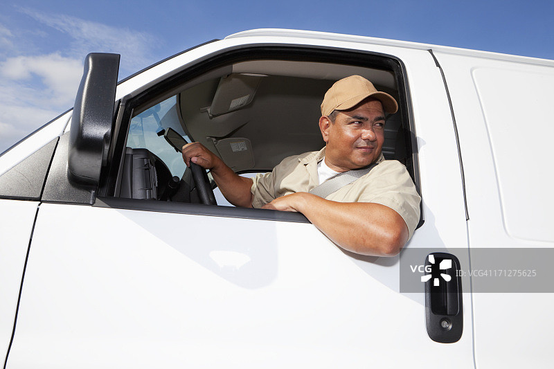 驾驶面包车的西班牙裔工人图片素材