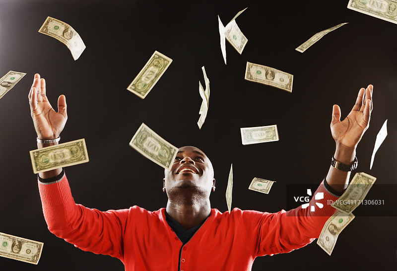 快乐男人沐浴在美元中图片素材
