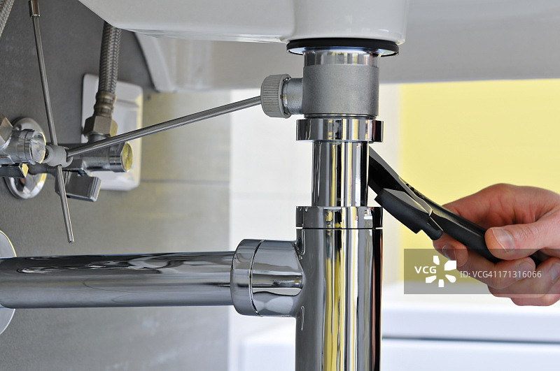 水管工在水槽处维修的特写镜头图片素材