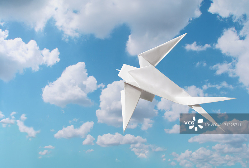 蓝色天空下的空白折纸燕子，带文案空间图片素材