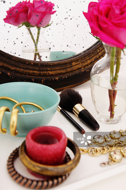 梳妆台，配有珠宝和粉红玫瑰花瓶图片素材