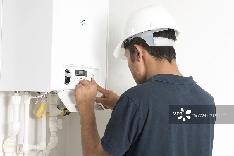 男技师在白色房间锅炉内工作图片素材