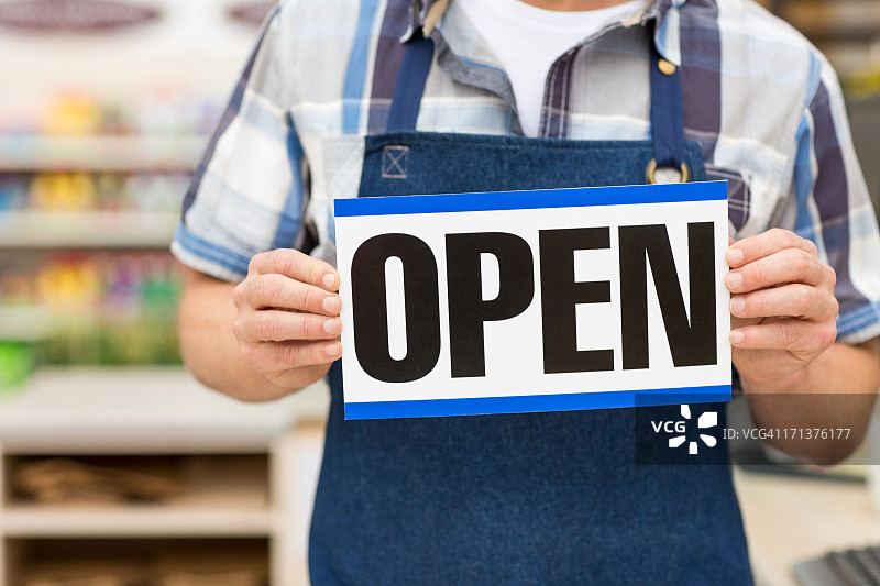 店主拿着打开的标牌图片素材