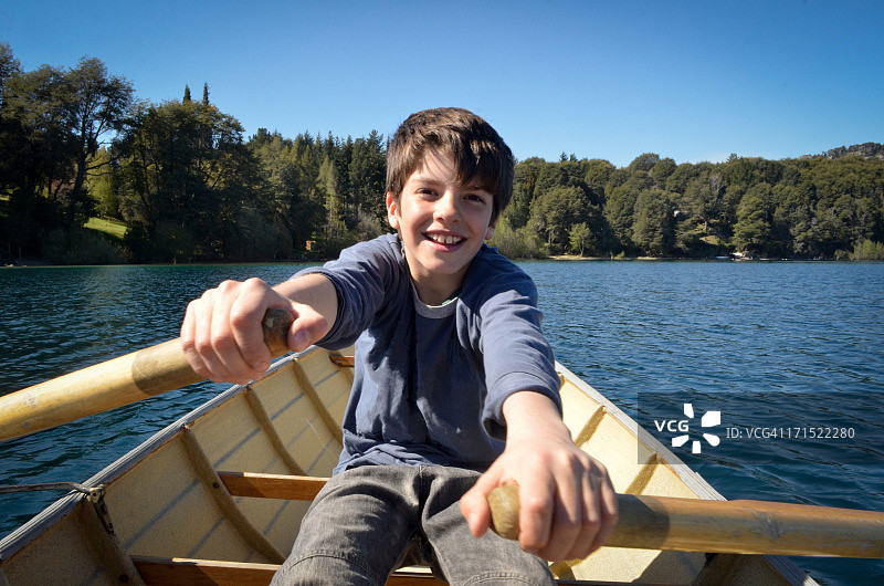男孩在湖上划船图片素材
