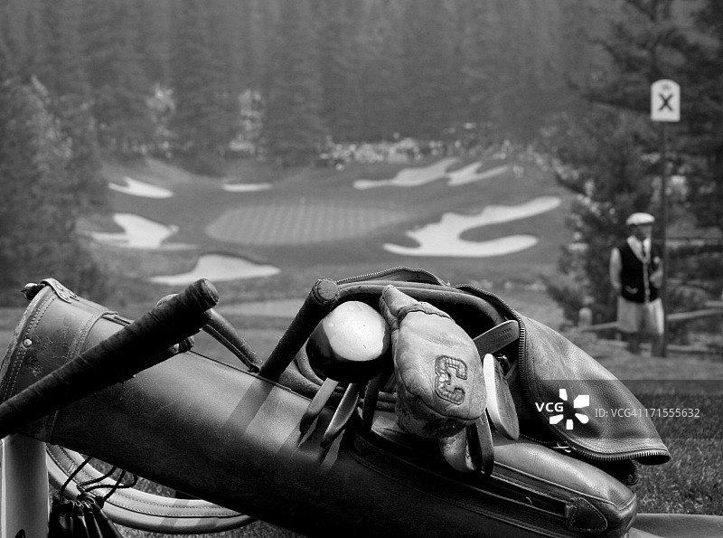 包括皮包和山核桃木杆的古董高尔夫设备图片素材