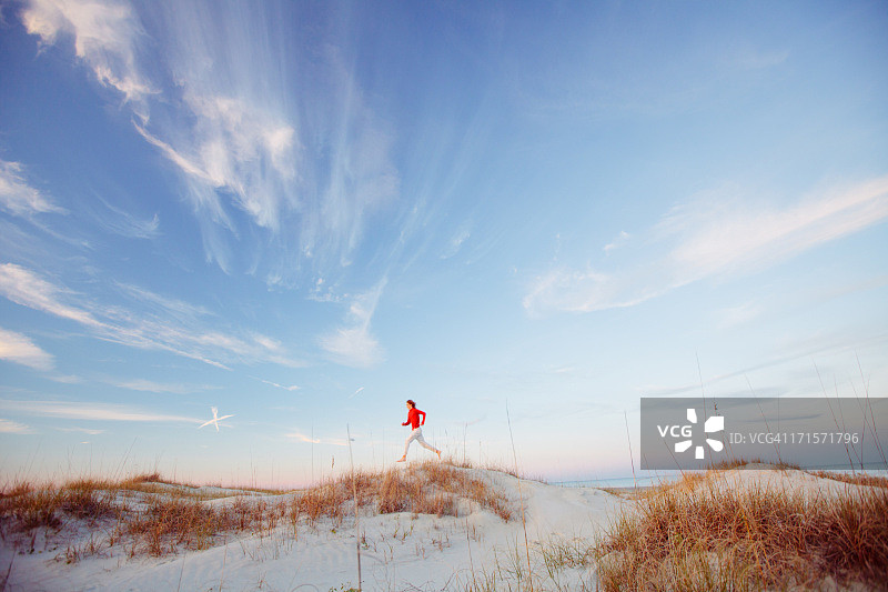 在海滩上跑步的年轻健康男人图片素材