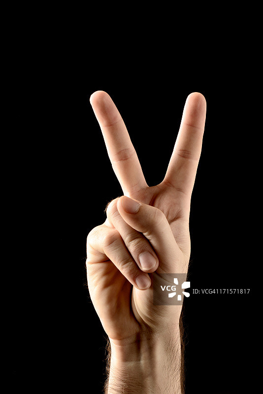 黑色背景上的胜利/和平手势图片素材