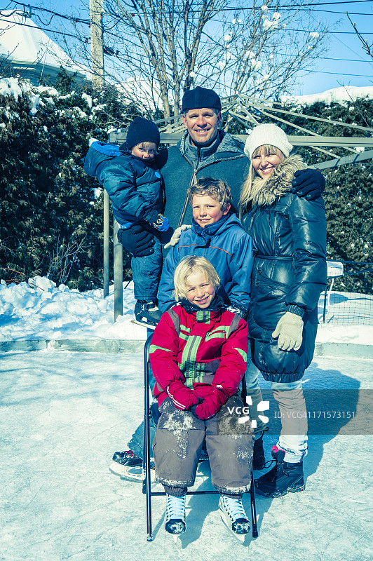 在自制溜冰场上摆姿势的真实一家五口图片素材