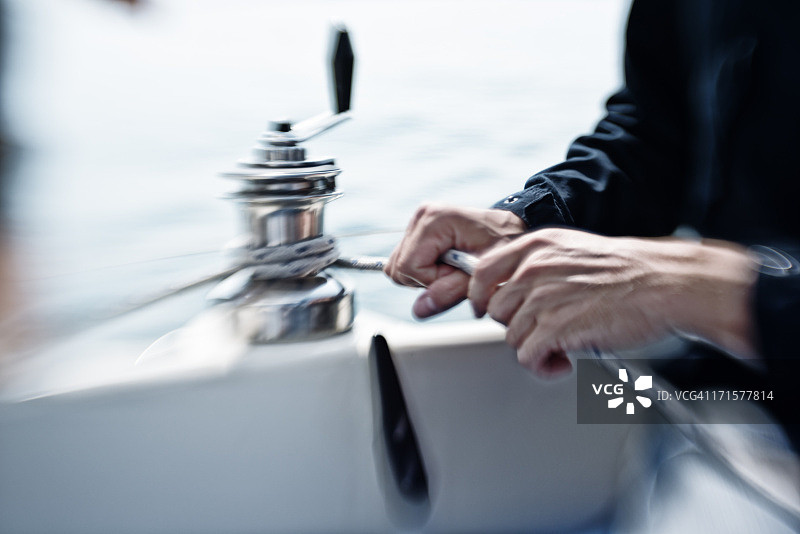 男人在航行中操作绞盘图片素材