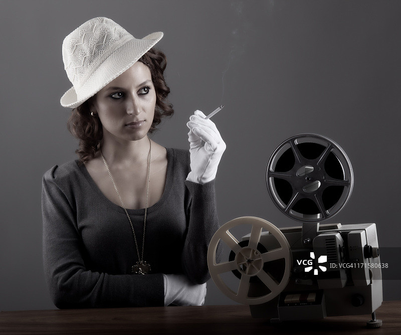 观看8毫米胶片的老式风格女人图片素材