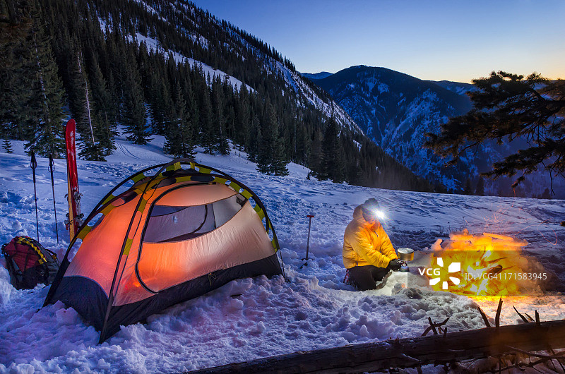 男子在燃气灶上烹饪的冬季野营图片素材