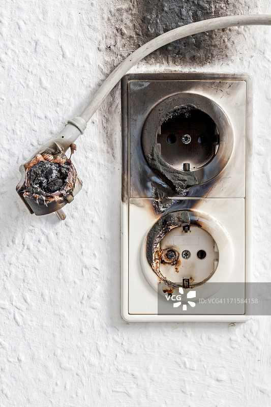 电线和墙壁插头引起的电气火灾特写图片素材