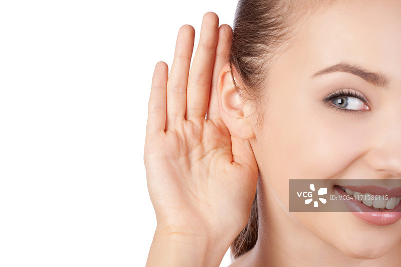 年轻女人用手放在耳朵上听图片素材
