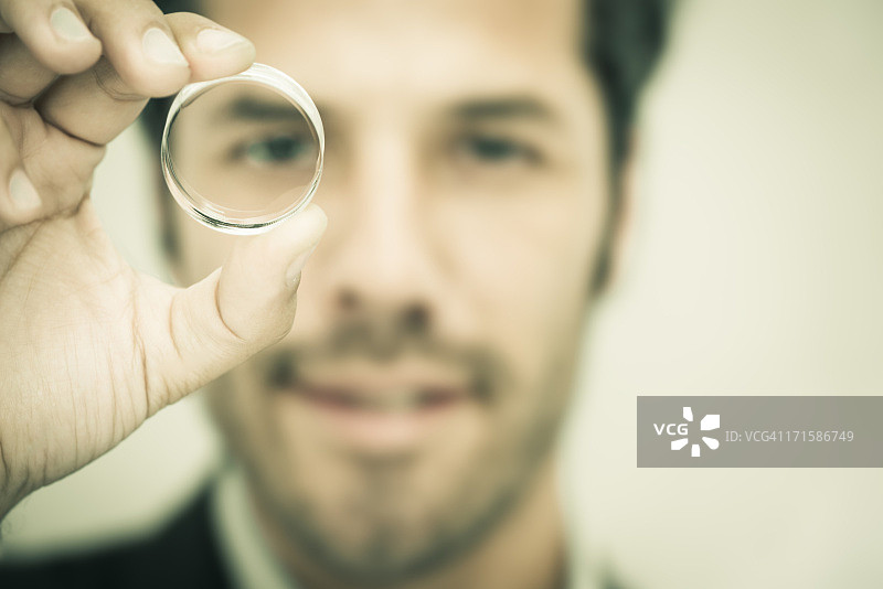 商务人士透过圆形镜头观看图片素材