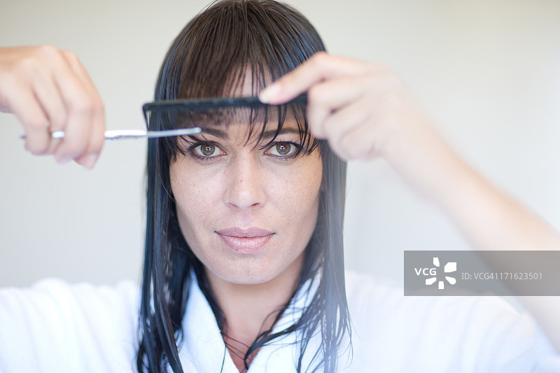 中年妇女自己剪刘海图片素材