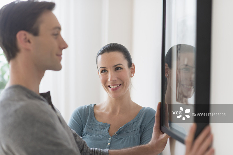 美国新泽西州泽西市，情侣在墙上挂画图片素材