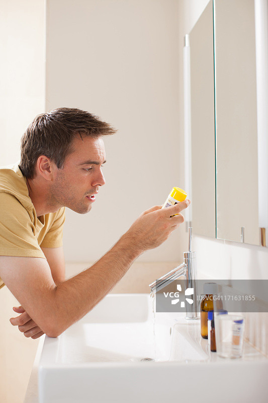 男人阅读药瓶上的说明图片素材