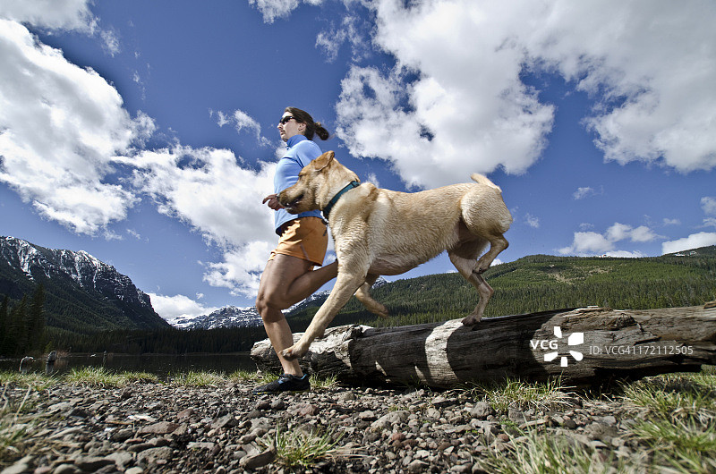 年轻女人和她的狗一起奔跑图片素材