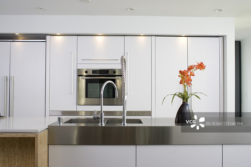 现代白色厨房，配有不锈钢台面和烤箱图片素材