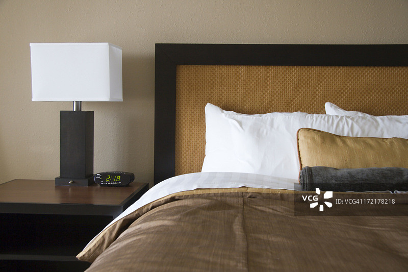 带白色方形灯罩的台灯和棕白色床图片素材