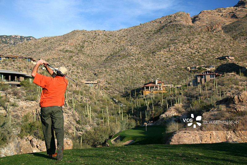 在沙漠高尔夫球洞上的年长的白人男性高尔夫球手图片素材