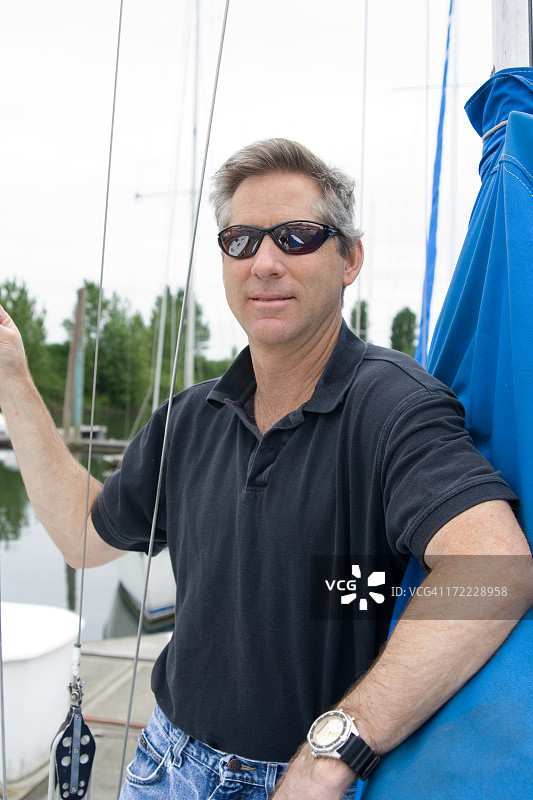 男人靠在帆船的桅杆上图片素材