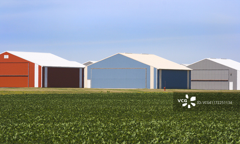 蓝天下绿色夏季田野旁的公用设施存储建筑图片素材