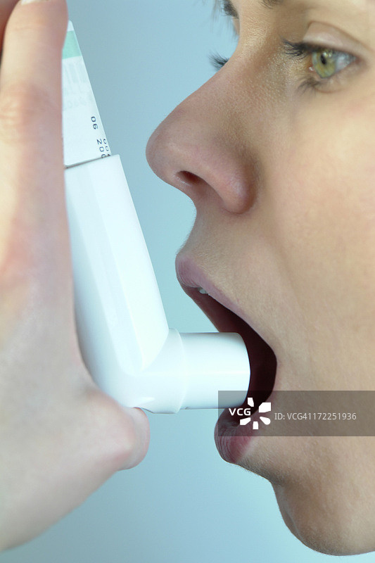 女人手持哮喘吸入器特写图片素材