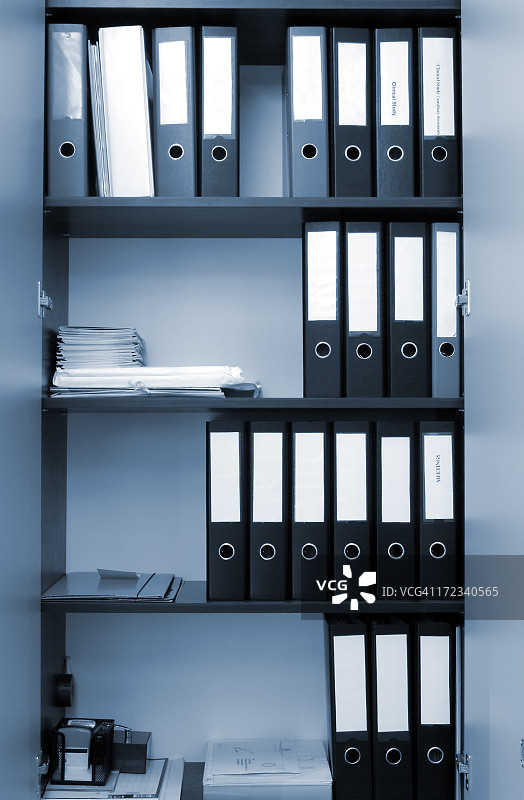 蓝色调书架上的一排环形活页夹图片素材