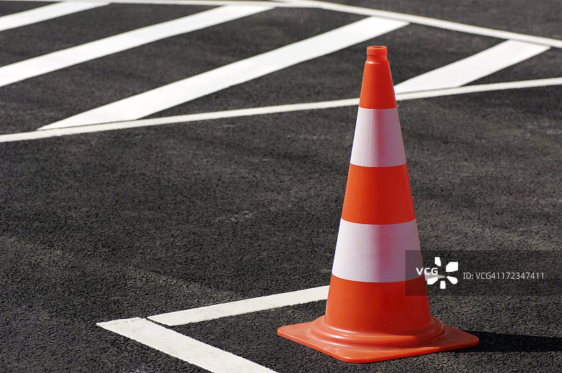 黑色路面上的橙色交通锥图片素材